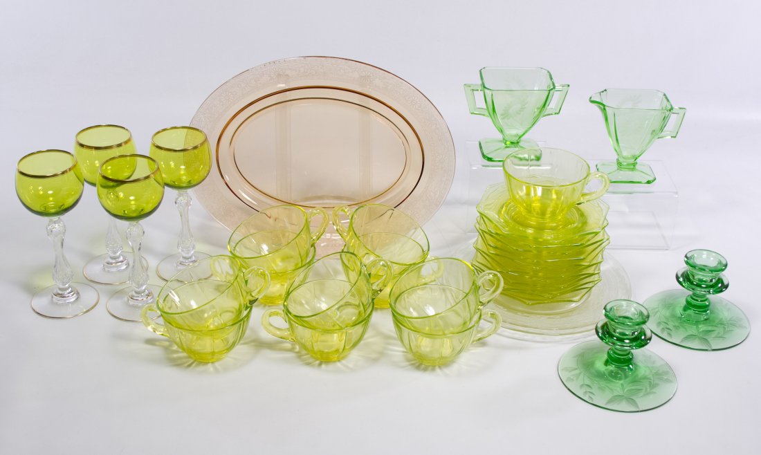 Depression Glass Assortment: Depression Glass Assortment Including light and dark green Vaseline glass plates, candlesticks, cups and saucers, a pink oval platter and gold rimmed goblets Length: 12.00 inches (platter) Category: G