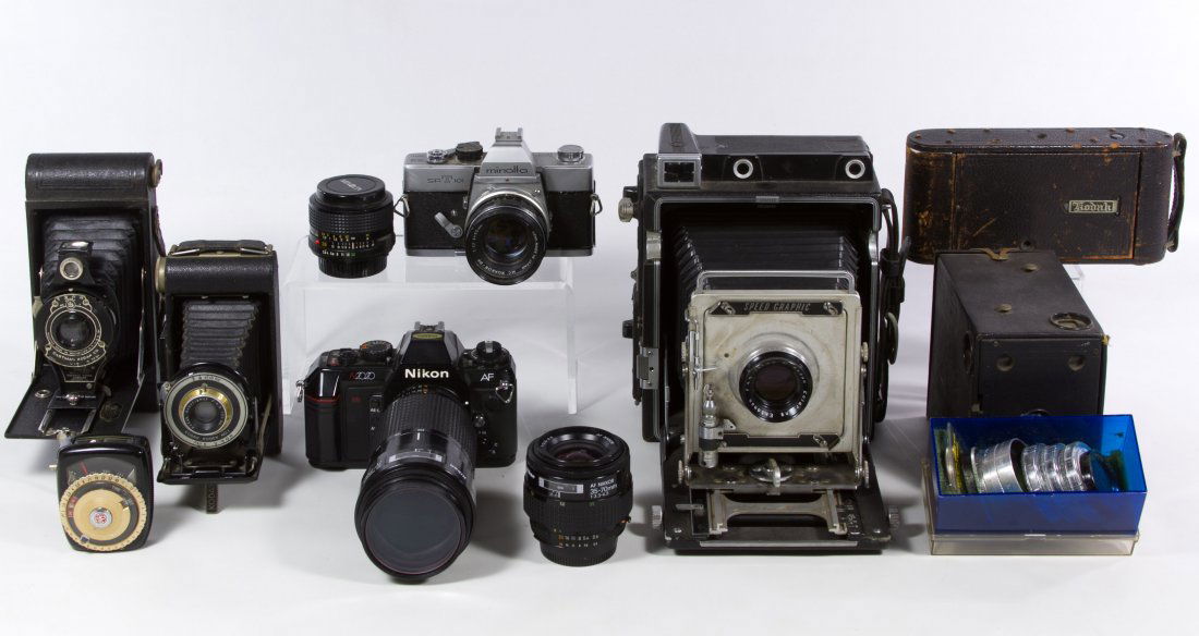 Camera Assortment: Camera Assortment Seven cameras including examples from Nikon, Minolta, Kodak and Graflex; together with camera lenses, tripod, timer, lights and a camera bag Height: 46.00 inches (tripod) Category: C
