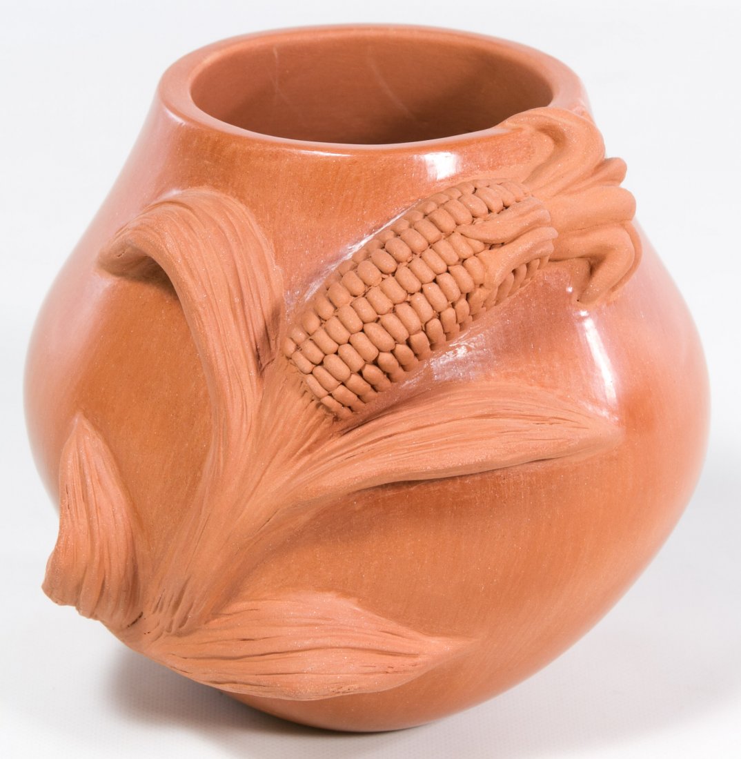 Pueblo Pottery 'Corn' Jar by Caroline Carpio: Pueblo Pottery 'Corn' Jar by Caroline Carpio Having a matted, terra cotta color vessel with a raised ear of corn motif and signature on the underside Height: 5.00 inches, Width: 5.00 inches Category: 