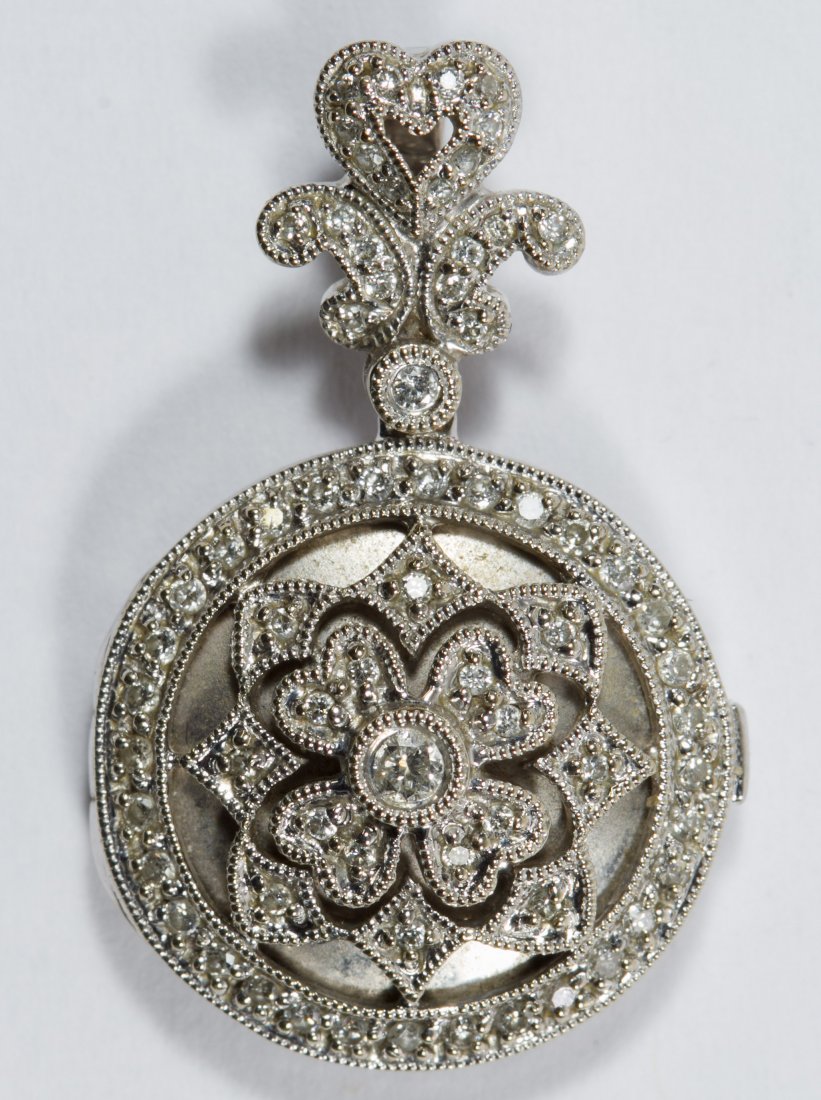 18k White Gold and Diamond Locket: 18k White Gold and Diamond Locket A round-shaped locket with a fleur des lis bail; marked 750 on attached bail Length: 1.13 inches Weight: 4.76 dwts. (total weight) Category: Jewelry & Timepieces > 18