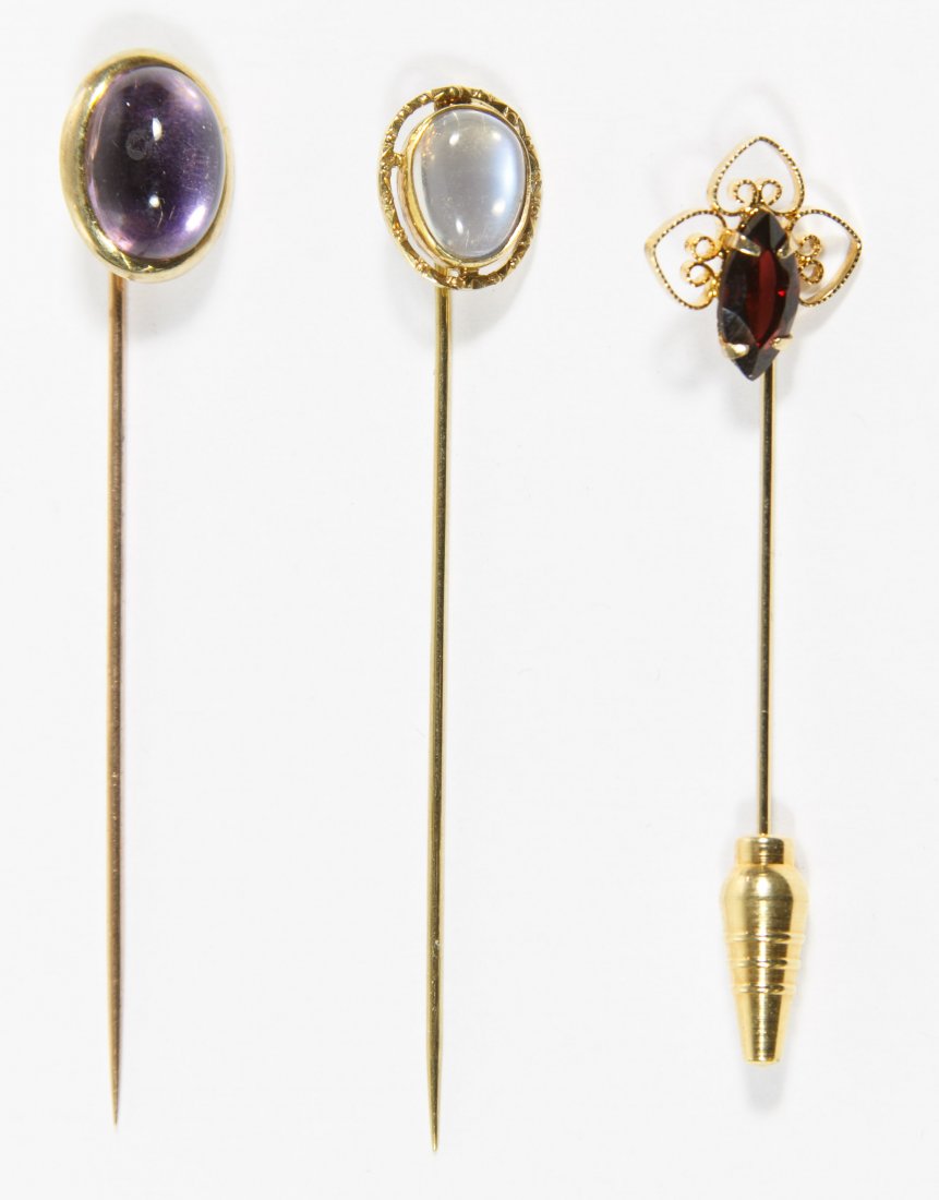 14k Gold Stickpin Assortment: 14k Gold Stickpin Assortment Three items including a 14k gold and moonstone stickpin; together with a 12k gold filled and garnet stickpin and a gold tone metal pin with amethyst Length: 4.00 inches (l