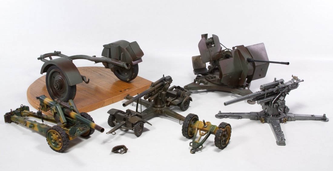 Metal Toy Artillery Model Parts: Metal Toy Artillery Model Parts Including three metal cannons with moving parts and an artillery style gun on a wheeled platform; together with a wooden display base Height: 9.00 inches, Width: 13.00 