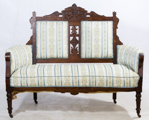 Eastlake Walnut Upholstered Settee: Eastlake Walnut Upholstered Settee Having castors on all four turned legs, a carved crest and center splat; the upholstery matches that on the chairs in lot 645 Height: 42.25 inches, Width: 55.25 inch