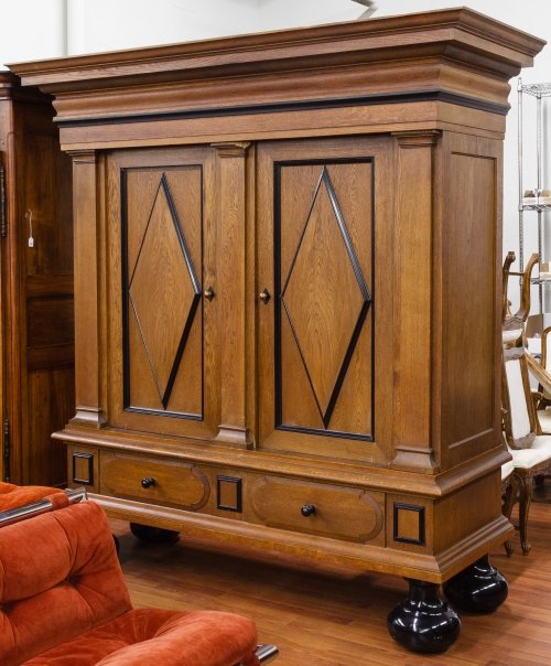 Oversized Entertainment Armoire: Oversized Entertainment Armoire Dutch, oak and ebonized wood having massive crown, two doors over two half drawers on bun feet; interior fitted with shelving Height: 88.00 inches, Width: 83.00 inches,