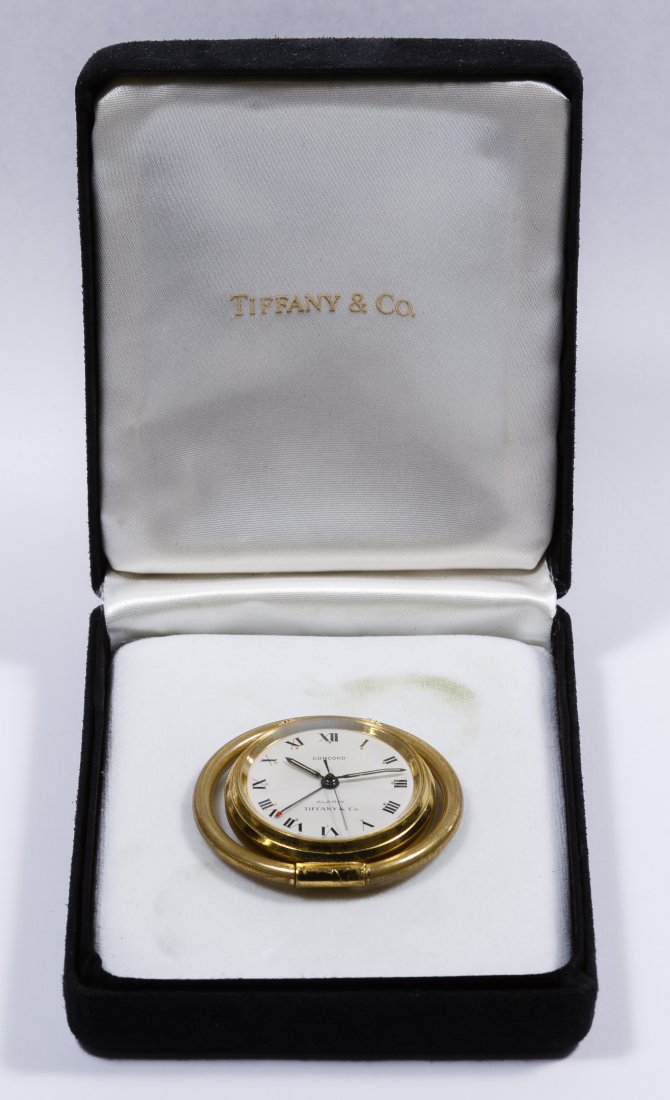 Tiffany & Co 'Concord' Travel Alarm Clock: Tiffany & Co 'Concord' Travel Alarm Clock Having a 17 jewel unadjusted #63 Swiss movement; brass case having an adjustable ring stand Diameter: 1.75 inches Category: Decorative Arts > Clocks Shipping 