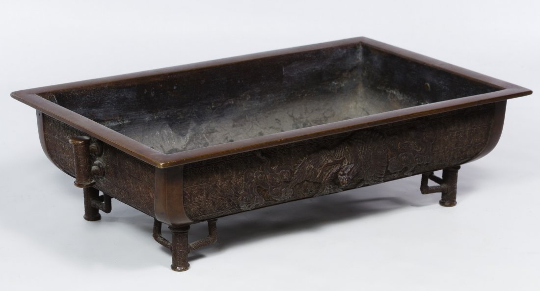 Asian Footed Bronze Planter: Asian Footed Bronze Planter 20th century, having four feet, two handles and dragon motif on the sides; stamped mark to the underside Height: 4.25 inches, Width: 15.00 inches, Depth: 9.00 inches Catego