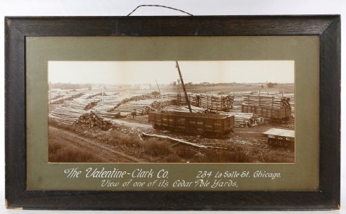 Chicago Northwestern Railroad Photograph: Chicago Northwestern Railroad Photograph c.1915, depicting the 'Cedar Pole Yards' of the Valentine-Clark Co. and a Northwestern railroad car Height: 10.25 inches, Width: 24.75 inches Frame Size: 19.50