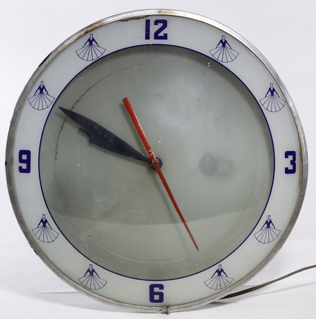 Electric Wall Clock by Advertising Products Inc.: Electric Wall Clock by Advertising Products Inc. Having a round glass bubble face, electric lights, metal rim and reverse painted images of a female with an Art Deco style skirt; made in Cincinnati, O
