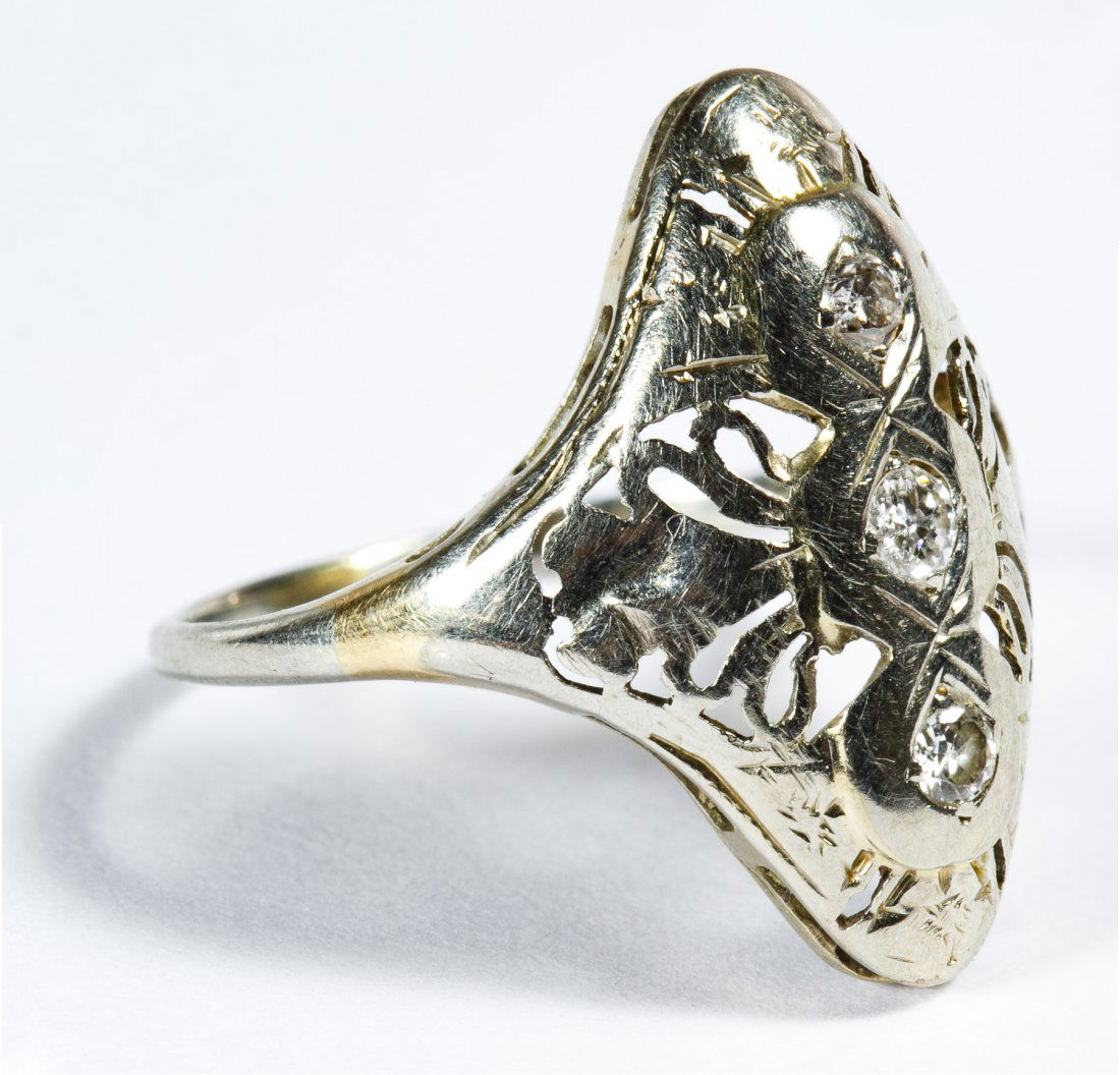 18k White Gold and Diamond Ring: 18k White Gold and Diamond Ring Having three round cut vertically set diamonds in an art deco style filigree setting; marked 18k inside band Size: 4 Weight: 1.21 dwts. (total weight) Category: Jewelry