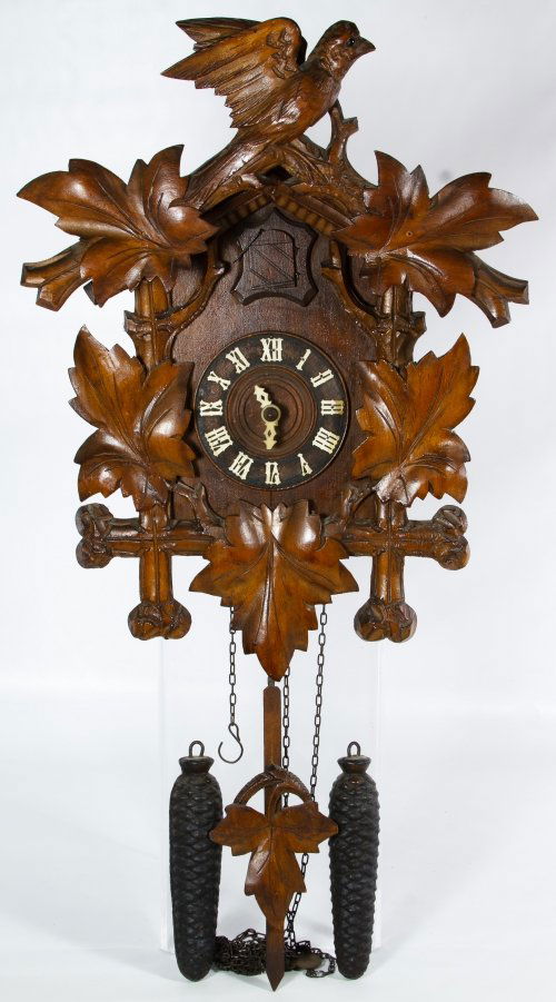 Black Forest Style Wooden Cuckoo Clock: Black Forest Style Wooden Cuckoo Clock Having a carved bird finial, leaf and branch form accented face, celluloid hands, two bellows, two pine cone metal weights, the pendulum and an unmarked mechanis