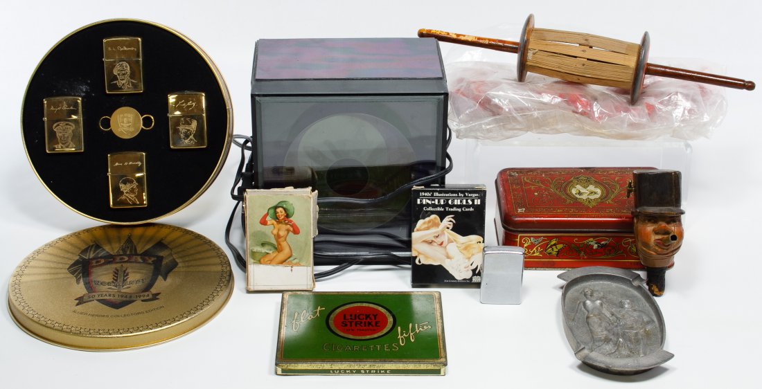 Tobacco Object Assortment: Tobacco Object Assortment Including tins, ash tray, lighters and a wood carved stopper with a cigar spout in the mouth; together with decks of cards and a Prisma II clock Width: 6.50 inches (widest ti