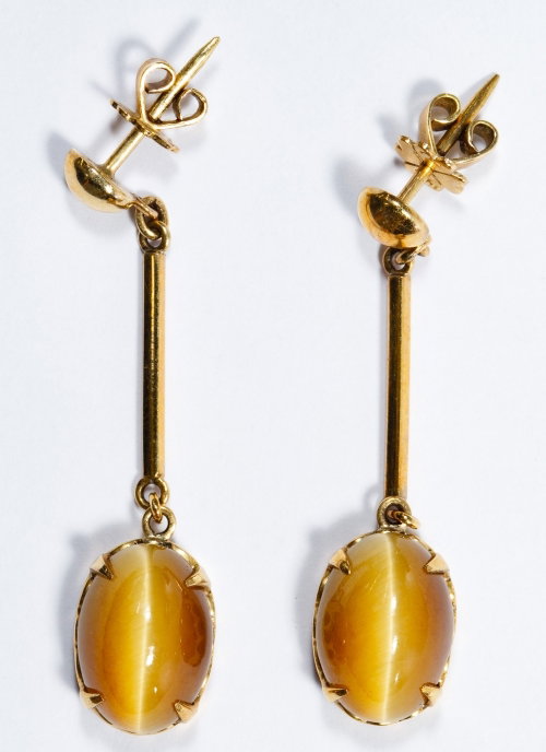 14k Gold and Cats Eye Pierced Earrings: 14k Gold and Cats Eye Pierced Earrings Pair, each having oval cut cabochon cats eye gemstones; marked 14k on earring backers Length: 1.75 inches Weight: 4.50 dwts. (total weight) Category: Jewelry & T