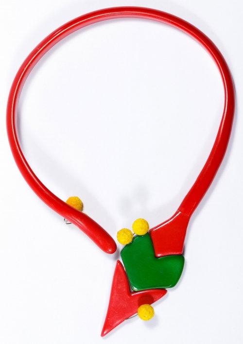 Ugo Correani Mid-Century Modern Asymmetrical Choker: Ugo Correani Mid-Century Modern Asymmetrical Choker Necklace Having a red arrow accented by a band of green and scattered yellow balls; signed on the back of arrow Length: 14.50 inches Category: Jewel