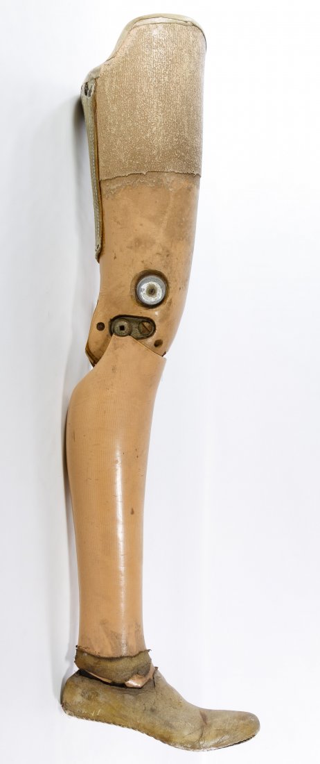 Artificial Prosthetic Male Right Leg: Artificial Prosthetic Male Right Leg Having a gesso covered burlap cloth over wood construction with a leather moccasin shoe and a hinged knee Height: 37.50 inches, Diameter: 24.00 inches (height oute