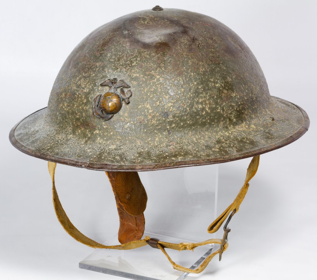 World War II USMC M1917A Helmet: World War II USMC M1917A Helmet Having an eagle, globe and anchor badge, a metal reinforced leather lining with a hand written soldier's name and a woven khaki chin strap Length: 12.00 inches, Width: 