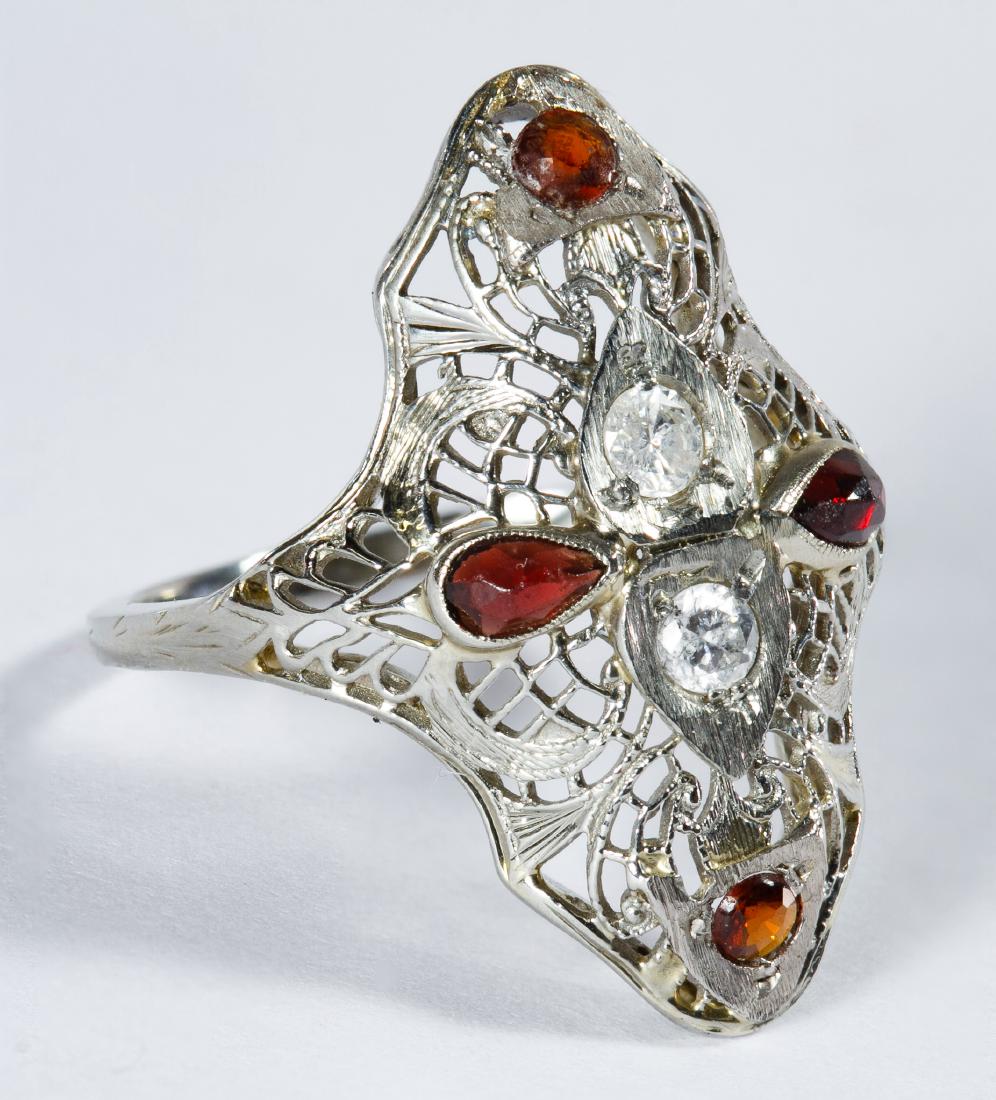 18k White Gold, Garnet and Diamond Ring: 18k White Gold, Garnet and Diamond Ring Art deco setting having two round cut diamond chips surrounded by round and pear cut garnets; marked '18k' inside band Size: 4.5 Weight: 1.29 dwts. (total weigh