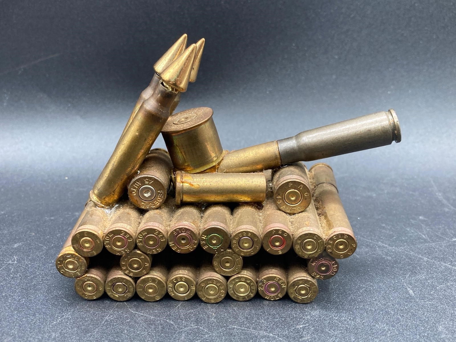 Pistol & Rifle Bullet Made Tank Model: Hand made tank model using pistol and rifle bullet casings. Model uses a variety of spent ammunition from Luger, Winchester and Remington. Measures 4" long, 3" tall and 2" deep. Model is in good condi