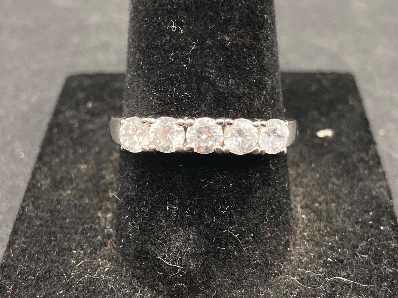 Sterling Silver Cubic Zirconia Band Ring Size 7.5: Sterling silver cubic zirconia band ring. Features five CZ stones set in sequence on .925 sterling silver band ring. Purity stamp noted in photos. Size 7 1/2, noted in photos. Ring is in good conditio