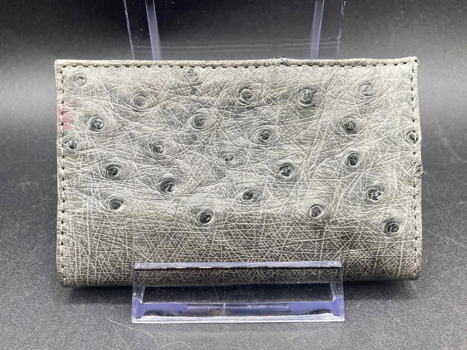 Genuine Ostrich Leather Bifold Wallet: Genuine ostrich leather bifold wallet. Features two inner pockets big enough for folded cash and cards. Gray color, measures 4" long. Good condition.Measurements: 2.5" W, 4" L, 1" H