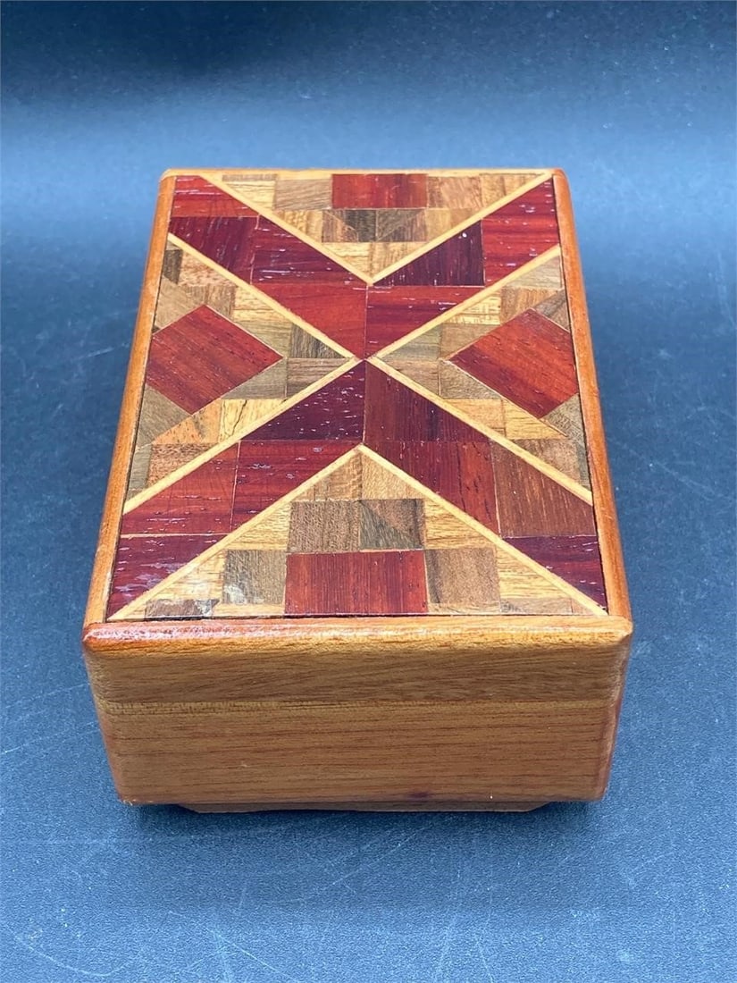 Wood Mystery Box: Wooden mystery box. Hand made box features intricate lid with many smaller fitted pieces of various shapes and colors. Lid won't open unless a secret tab is pushed. Box has some small scratches, other