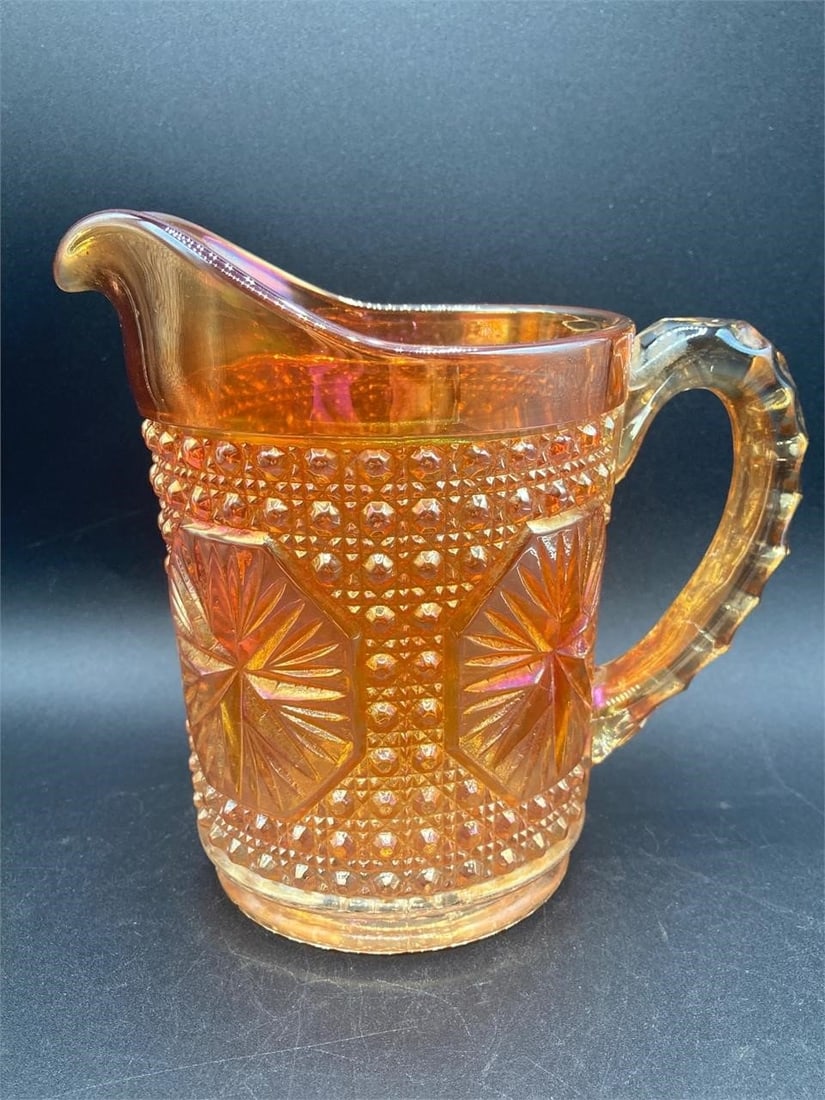 Carnival Glass Marigold Imperial Star Pitcher: Carnival glass iridescent marigold imperial star and buttons pitcher. Features star medallions and button patterns on glass that changes color under different lighting. Pitcher is in good condition.Me