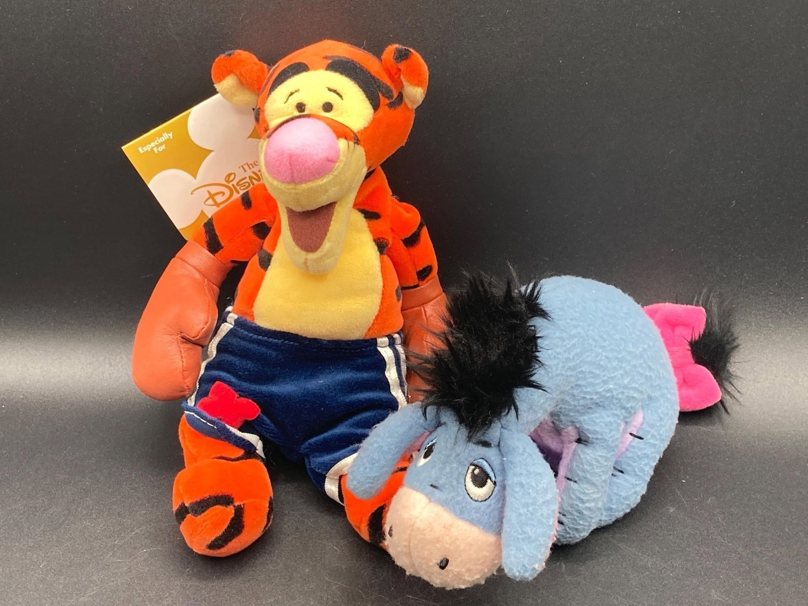 Disney Tigger & Eeyore Plush Dolls: Disney Store boxing Tigger & Eeyore plush dolls. Feature bean bag style Tigger plush with boxing trunks and gloves and bean bag style Eeyore plush. Tigger has original tag still affixed. Both plushes 