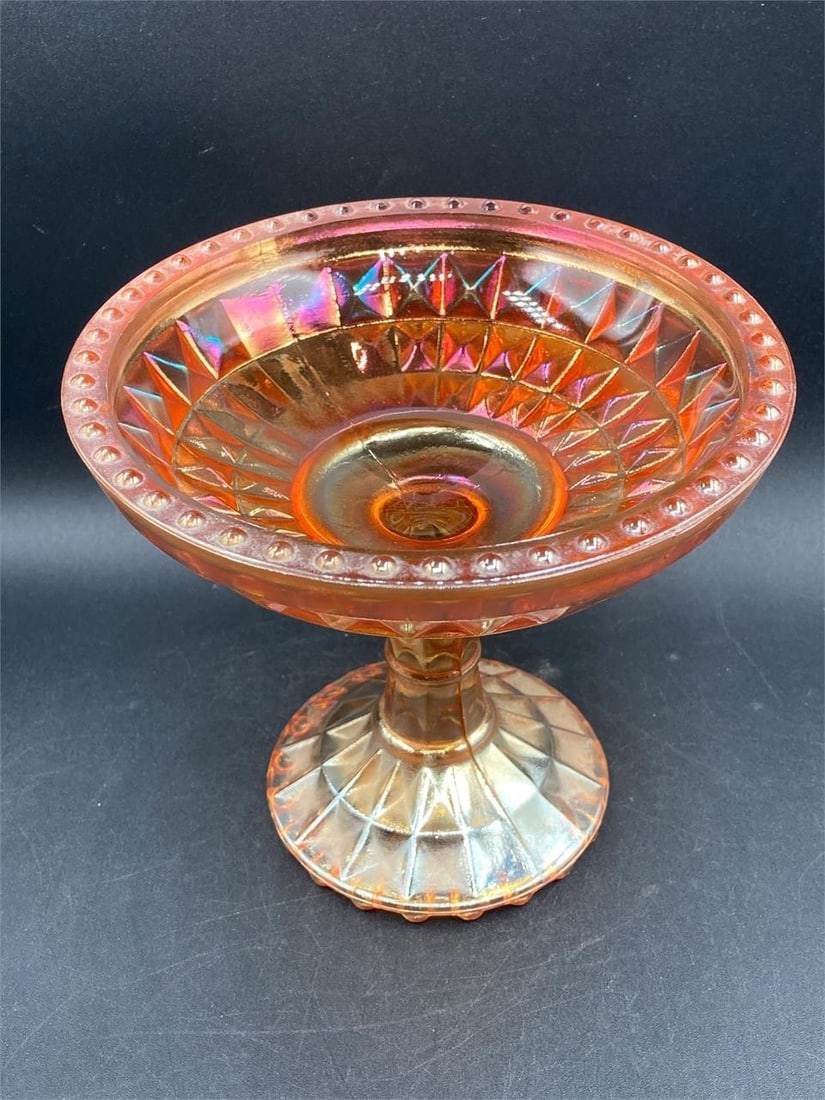 Carnival Glass Jeanette Marigold Diamond Compote: Carnival glass Jeanette iridescent marigold diamond compote. Features Diamond patterns and dotted rim on glass that changes color under different lighting. Measures 5.5" tall. Good condition.Measureme