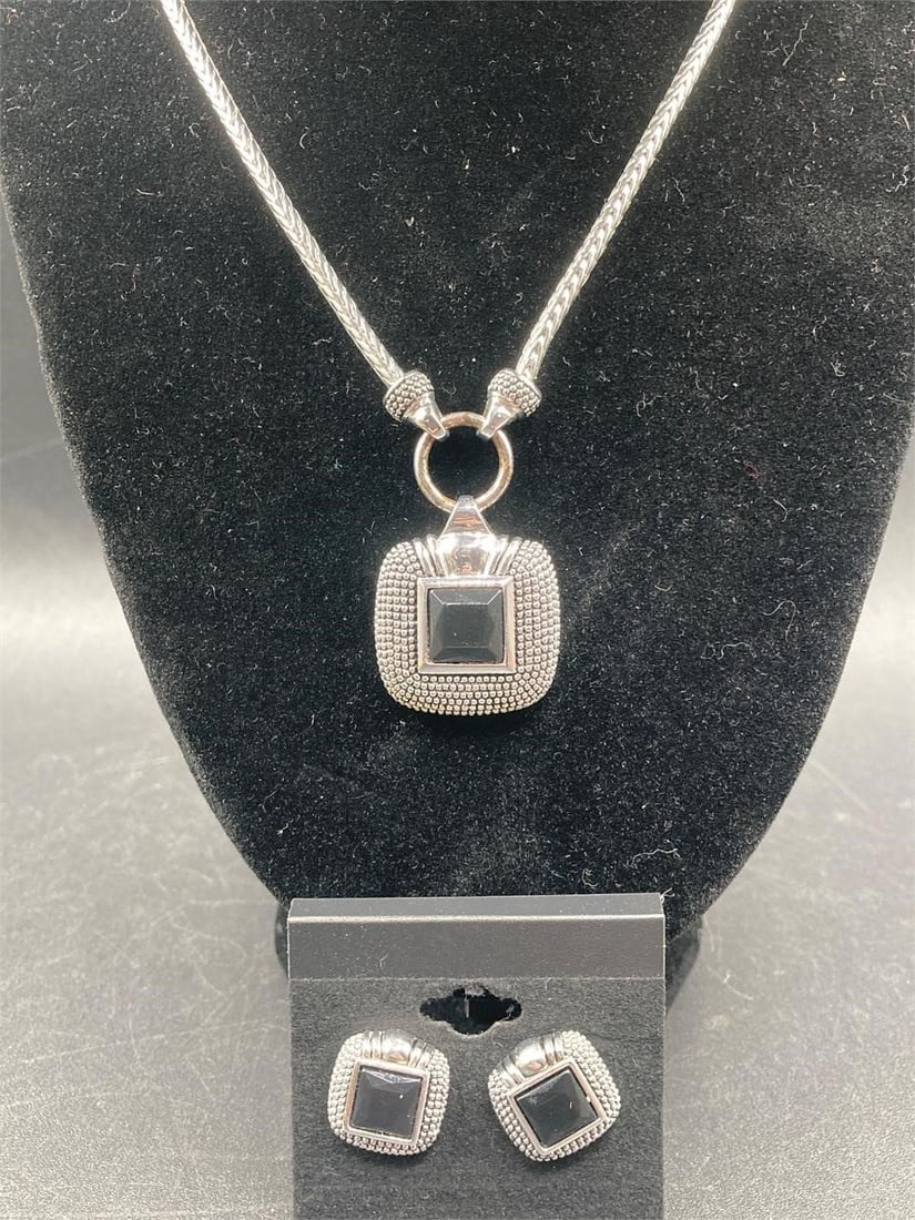 Silver Tone Black Faceted Stone Necklace & Earring: Silver tone black faceted stone necklace and earrings set. Matching set features silver tone charm with cut and polished black stone on braided rope style chain. Chain measures 16" long. Set is in goo