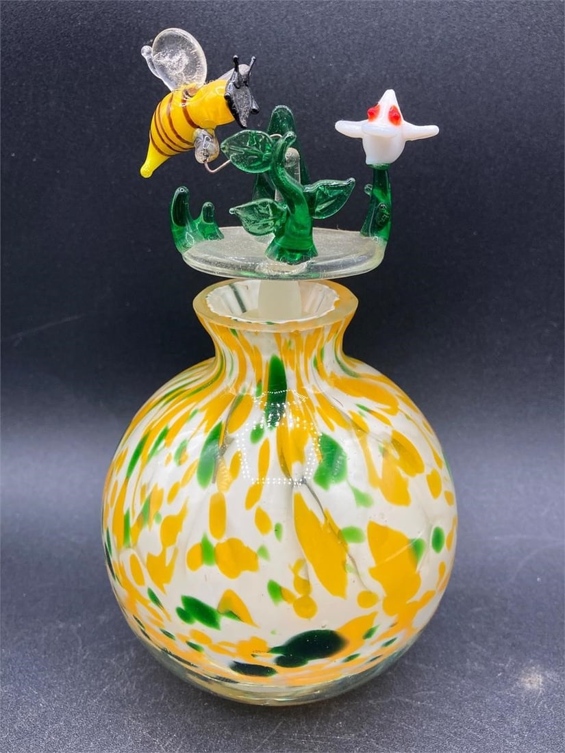 Murano Glass Bee Perfume Bottle: Hand made Murano glass bee and flower perfume bottle. Features bee, flower and plant designed stopper and green, white and yellow colored glass with random patterns. Bottle is in good condition.Measur