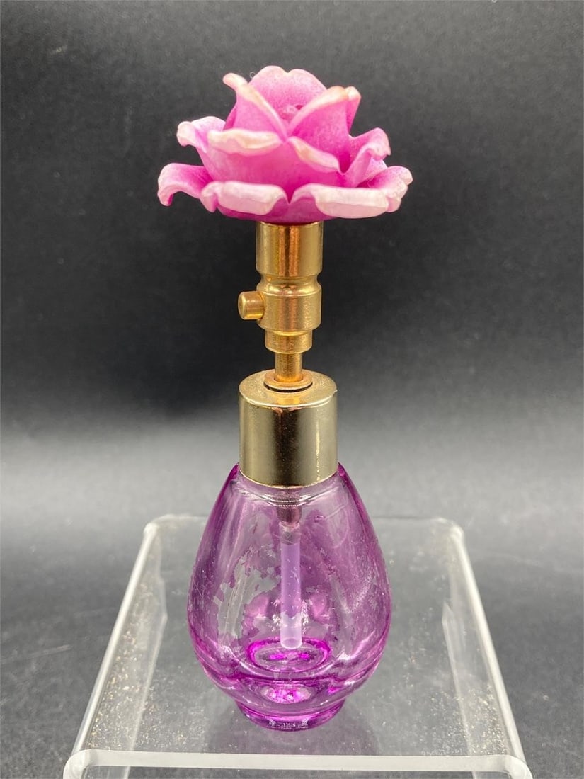 Vintage Purple Glass Flower Top Perfume Bottle: Vintage purple glass flower top atomizer perfume bottle. Features purple flower designed cap top, purple colored glass and gold tone sprayer. Measures 4" tall. Coloring on bottle is worn in areas as n