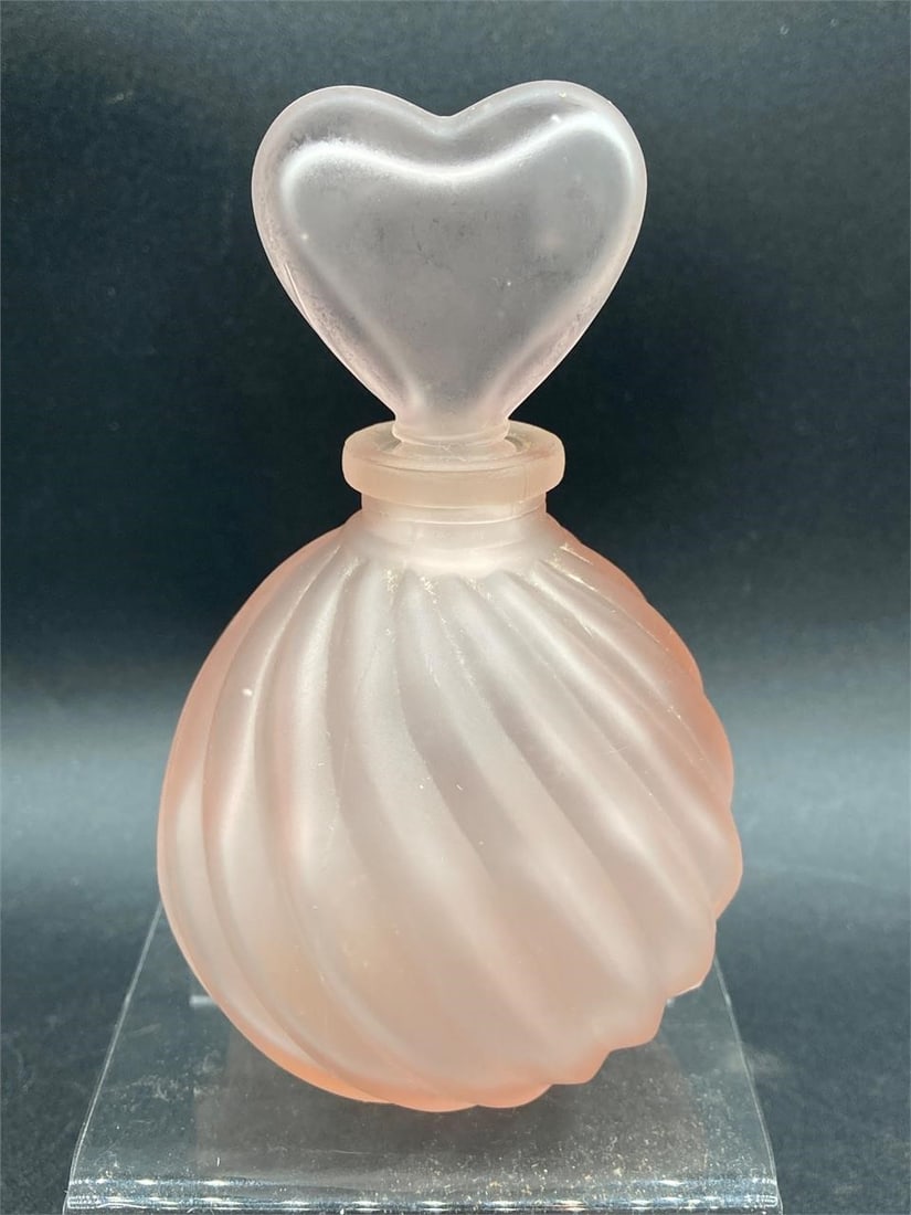 Vintage Cows Heads frost pink heart perfume bottle. Features frosted pink glass with heart shaped: Vintage Cows Heads frost pink heart perfume bottle. Features frosted pink glass with heart shaped stopper and spiral body. Measures 4 1/2" tall. Small residue spot at bottom of bottle, otherwise good