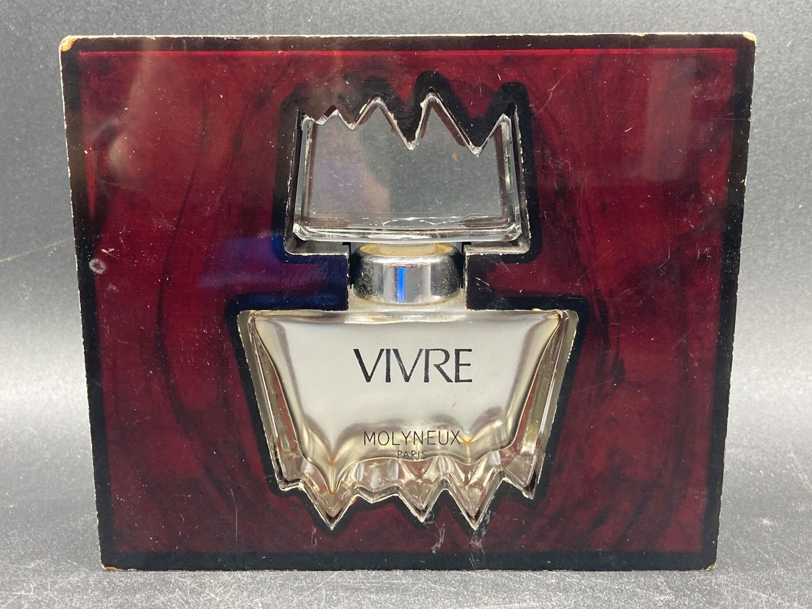 Vivre Molyneux Perfume Bottle: Vivre Molyneux perfume bottle in original box. 30ml sized bottle. Features sawtooth rimmed stopper and sawtooth feet on bottle. Some residue inside bottle and light scratches on box, otherwise item is