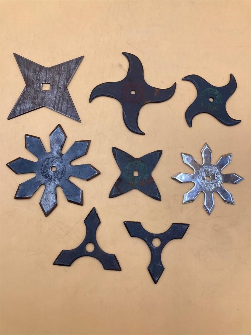 Japanese Shuriken Throwing Stars: Set of eighth Japanese made shurikens. Shurikens are in various shapes with etched dragon designs on middle of many of the throwing stars. Some light rust on tips of some shurikens, otherwise they are