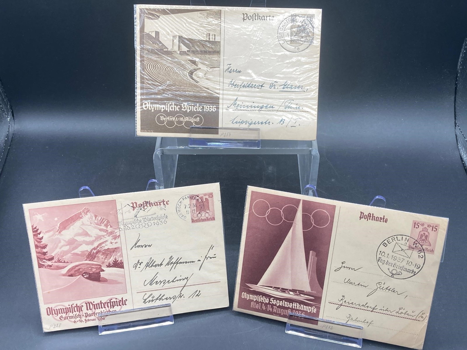 1936 Berlin Olympics Postcards: Set of three 1936 Berlin Olympics postcards with stamps and hand written notes. Cards are wrapped in plastic and are in good condition.Measurements: 5" L, 7" W, 1" H, 1 pound
