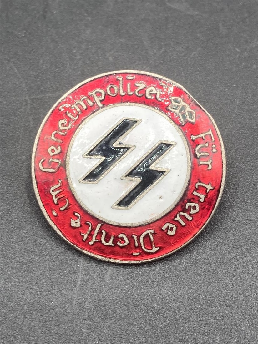 German WWII Waffen SS Shield Runner Badge: Original world war 2 German waffen SS enameled shield runner badge. Features SS symbol and script print ensnarled in vibrant colors. Maker stamp noted on back. Measures 4 centimeters. Missing screw ba
