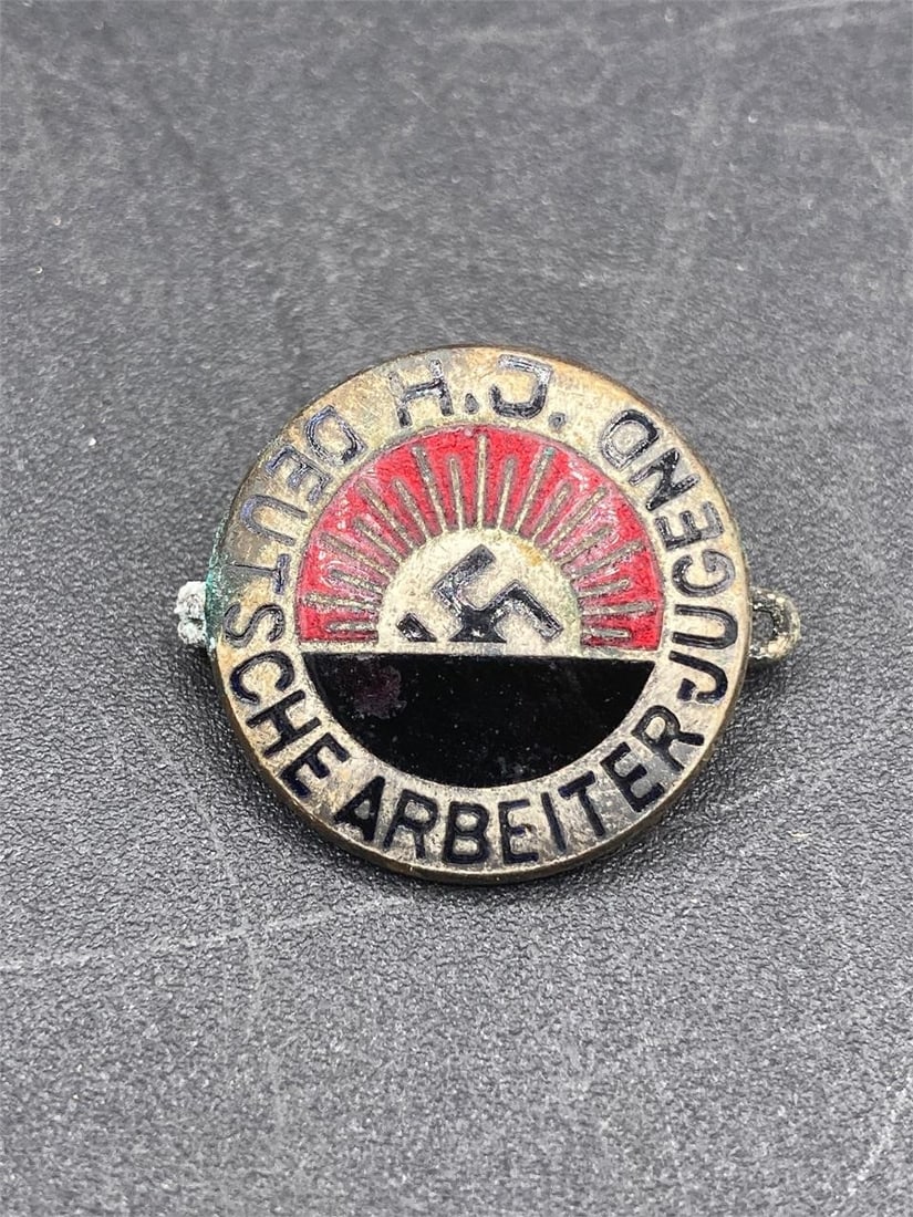 Original German WWII Hitler Youth Membership Badge: Original German world war II era Hitler youth membership badge. Early example with first design. Enameled NSDAP rising sun style symbol front. Measures 7/8". Backside has visible surface corrosion, an