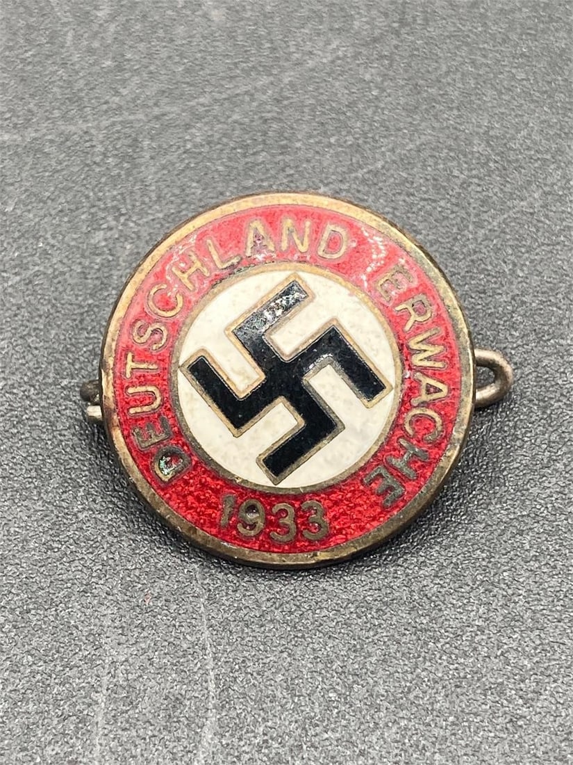 1933 German NSDAP Member Pin: 1933 German NSDAP member pin. Enameled front with NSDAP symbol and "Deutschland Erwache 1933" slogan. M1/129 and RZM stamps on back noted in photos. Measures 7/8". Some light wear on front, overall it