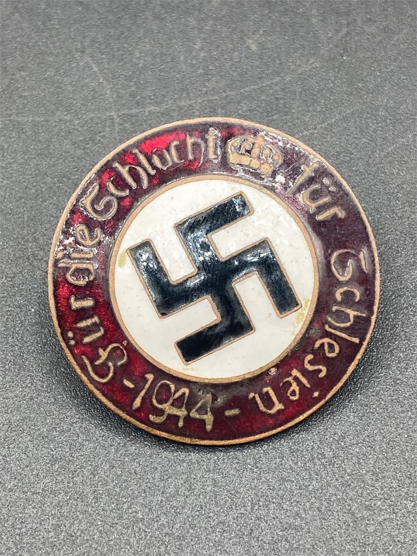 1944 German NSDAP Enamel Badge: World war 2 German 1944 NSDAP badge. "Fur die Schalcht fur Schlesien 1944" text. Enameled front with prominent NSDAP symbol. Screw back style, GES GESCH stamp noted on back. Measures 1 9/16". Item is 