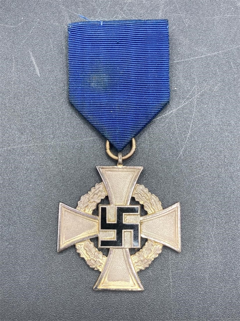 WWII German 25 Year Faithful Service Medal: World war II German 25 years faithful service medal with ribbon. Enameled NSDAP symbol center on wreathed cross. Medal measures 1 1/2". Some wear on medal and stain on ribbon, overall item is in good