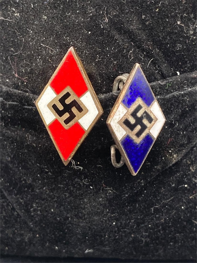 WWII German NSDAP Hitler Youth Pins: Set of two World War Two German NSDAP Hitler youth badge pins. Features a blue and a red variant. RZM stamps and numbers noted on backside, M1/42 on back of red pin. Pins measure 1" and are both in ex