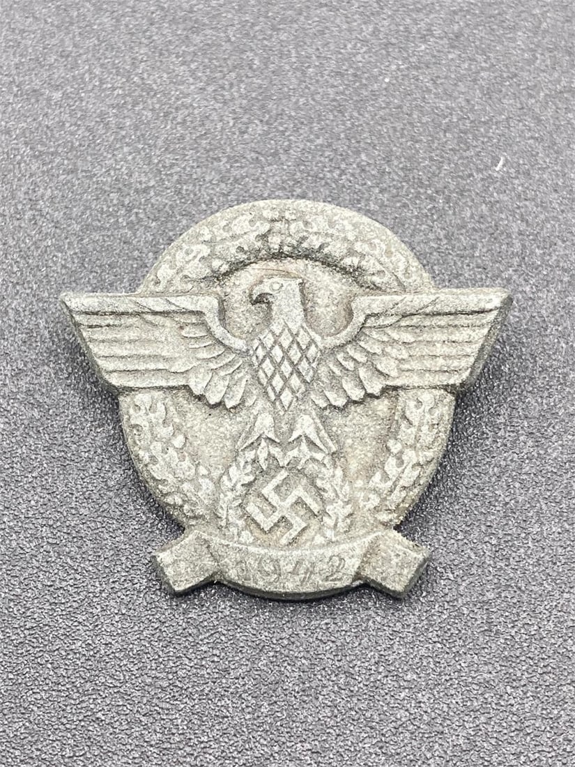 WWII German 1942 Police Donation Tinnie: World War II German 1942 police donation tinnie pin. NSDAP eagle front design. H2 stamp on back. Measures 1". Pin is in very good condition.Measurements: 1" W, 1" L, 1" H, 1 pound