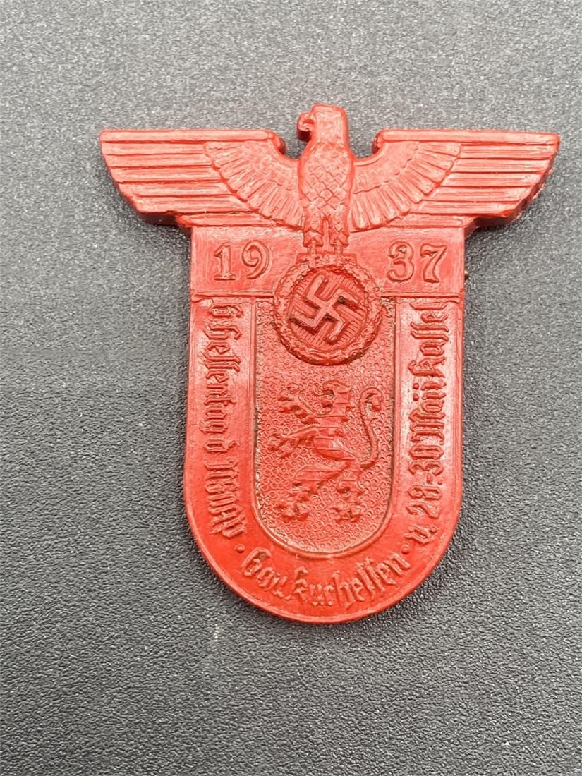 1937 6Th Hessen District Day Of The NSDAP Tinnie: 1937 6th Hessen district NSDAP party day tinnie. Red plastic with city shield logo and NSDAP eagle front. Maker mark on back. Measures 1 3/4" long. Tinnie is in excellent condition.Measurements: 2" W,