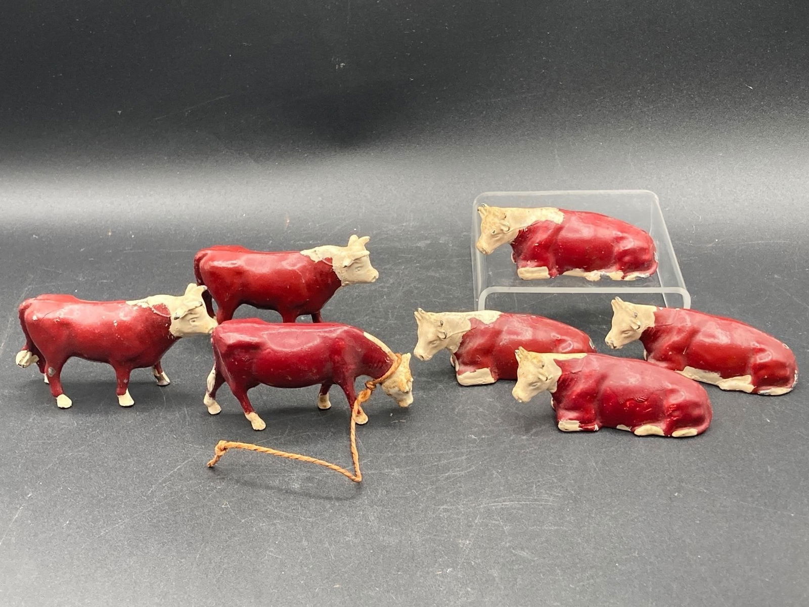 Vintage cast iron cow toys. Set of seven hand painted cows in upright, resting and grazing (1 of 7)