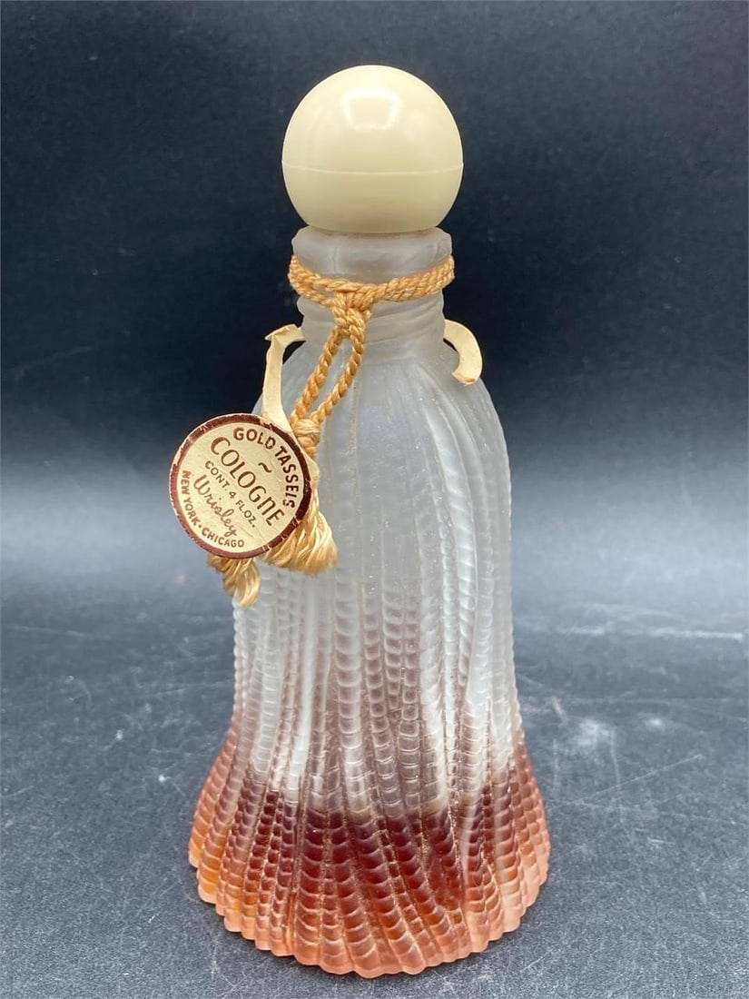 Vintage Wrisley gold tassels four ounce perfume bottle. Frosted glass bottle with gold tone yarn and: Vintage Wrisley gold tassels four ounce perfume bottle. Frosted glass bottle with gold tone yarn and original label. Roughly 1/3 full. Item is in good condition.Measurements: 3" W, 3" L, 6" H, 1 pound