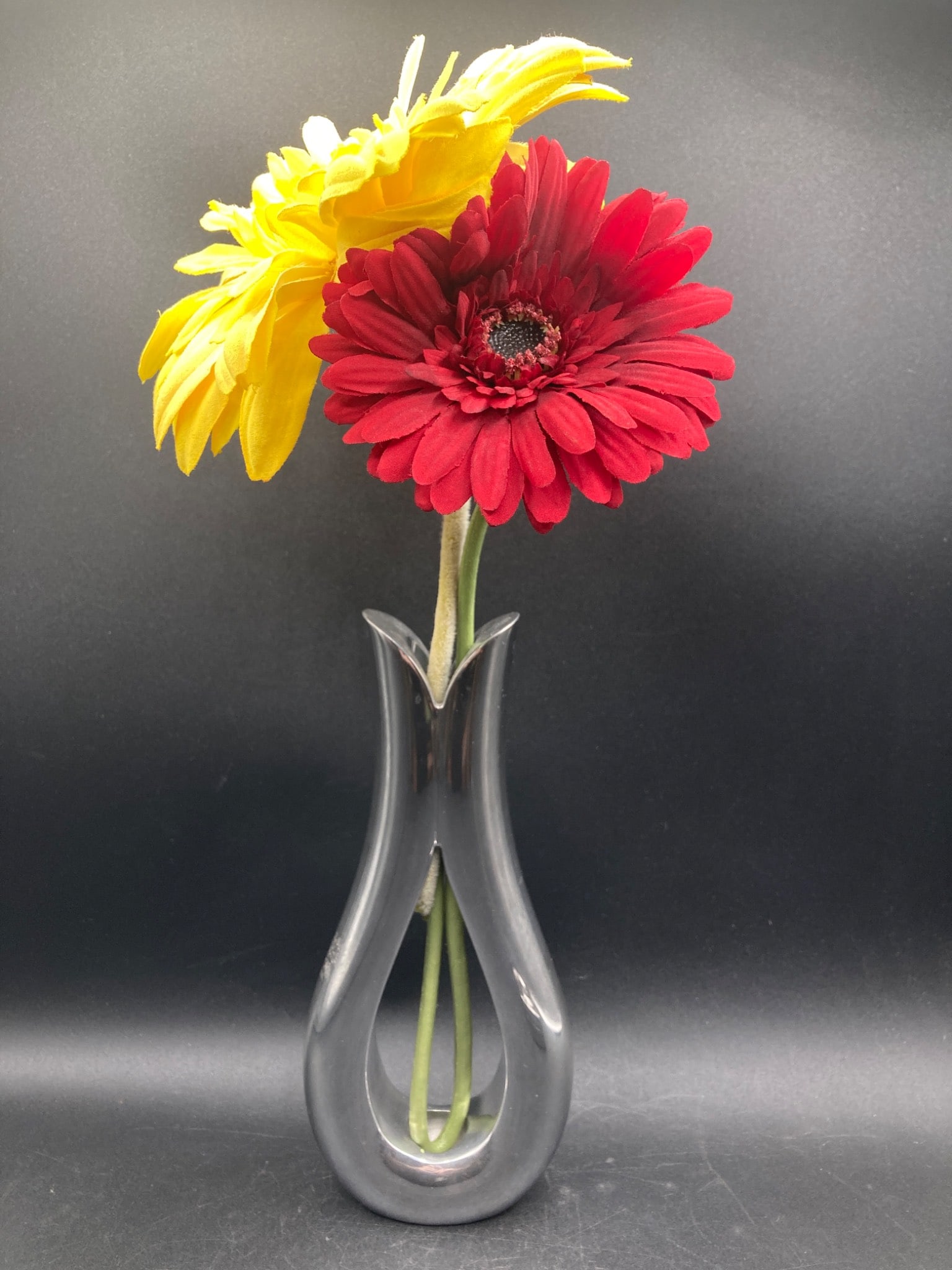 Nambe Flow Vase by Steve Cozzolino: This is a Nambe Flow Vase, model number MT0055, designed by Steve Cozzolino in 2009. The vase features an elegant, flowing design crafted from Nambe's signature metal alloy. Measuring 9 inches in heig