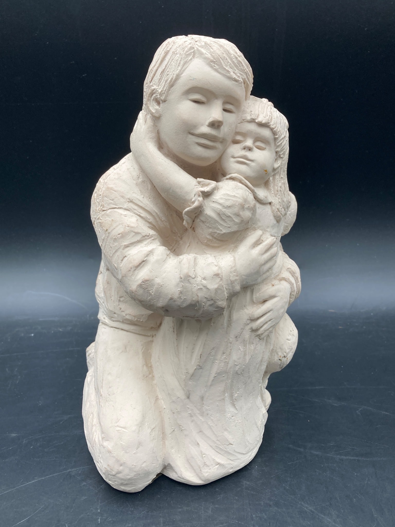 Austin Productions 1992 ‘Daddy's Little Girl' Sculpture: This item is a 1992 Austin Productions sculpture titled 'Daddy's Little Girl.' The sculpture depicts a father and young daughter in a tender embrace. It is crafted from a ceramic material with a textu