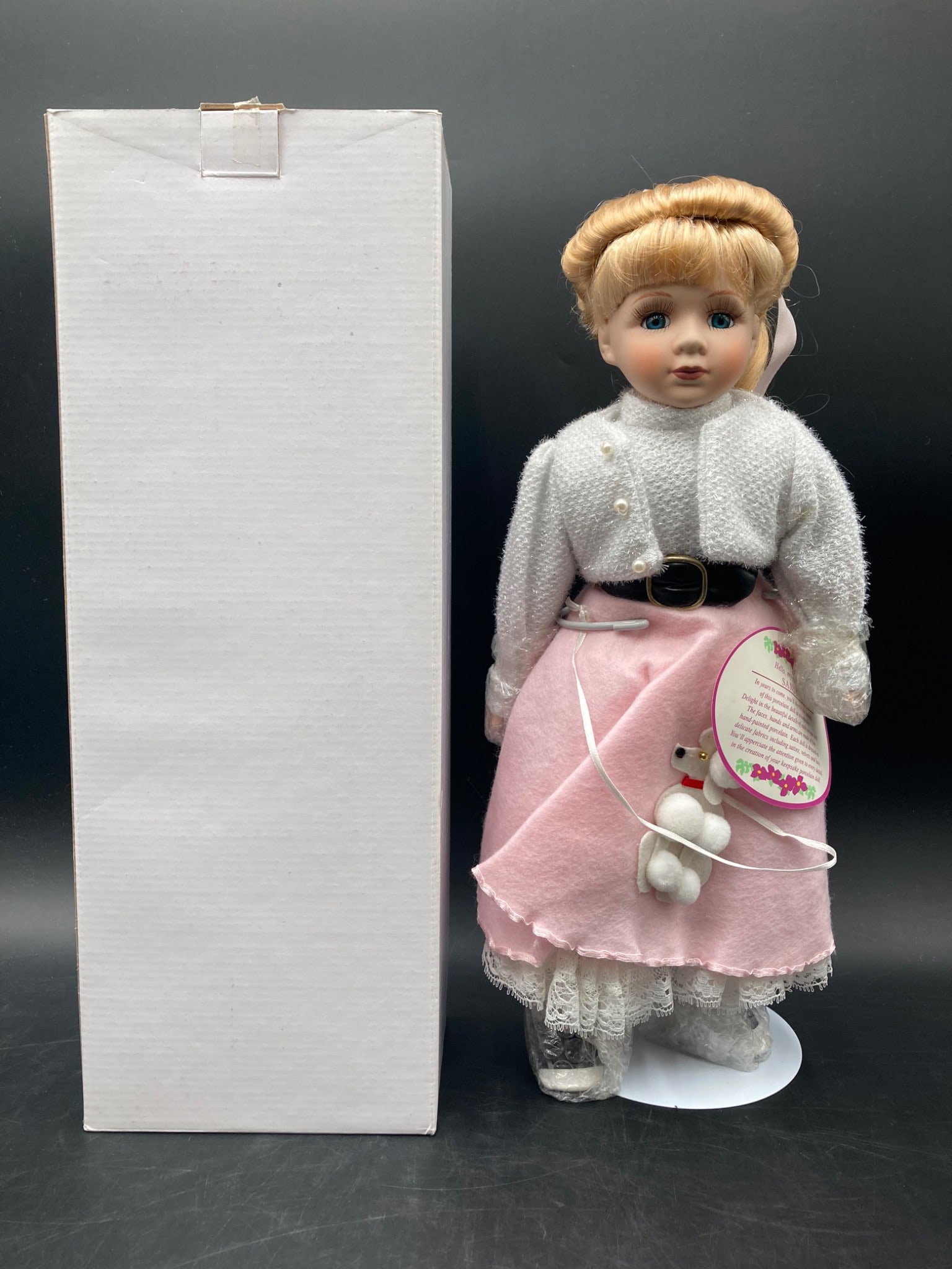 Keepsake Porcelain Dolls Sandi Doll: This listing is for a Keepsake porcelain doll named Sandi. The doll is in excellent condition and includes her original packaging. The doll features painted porcelain components, including a hand-pain