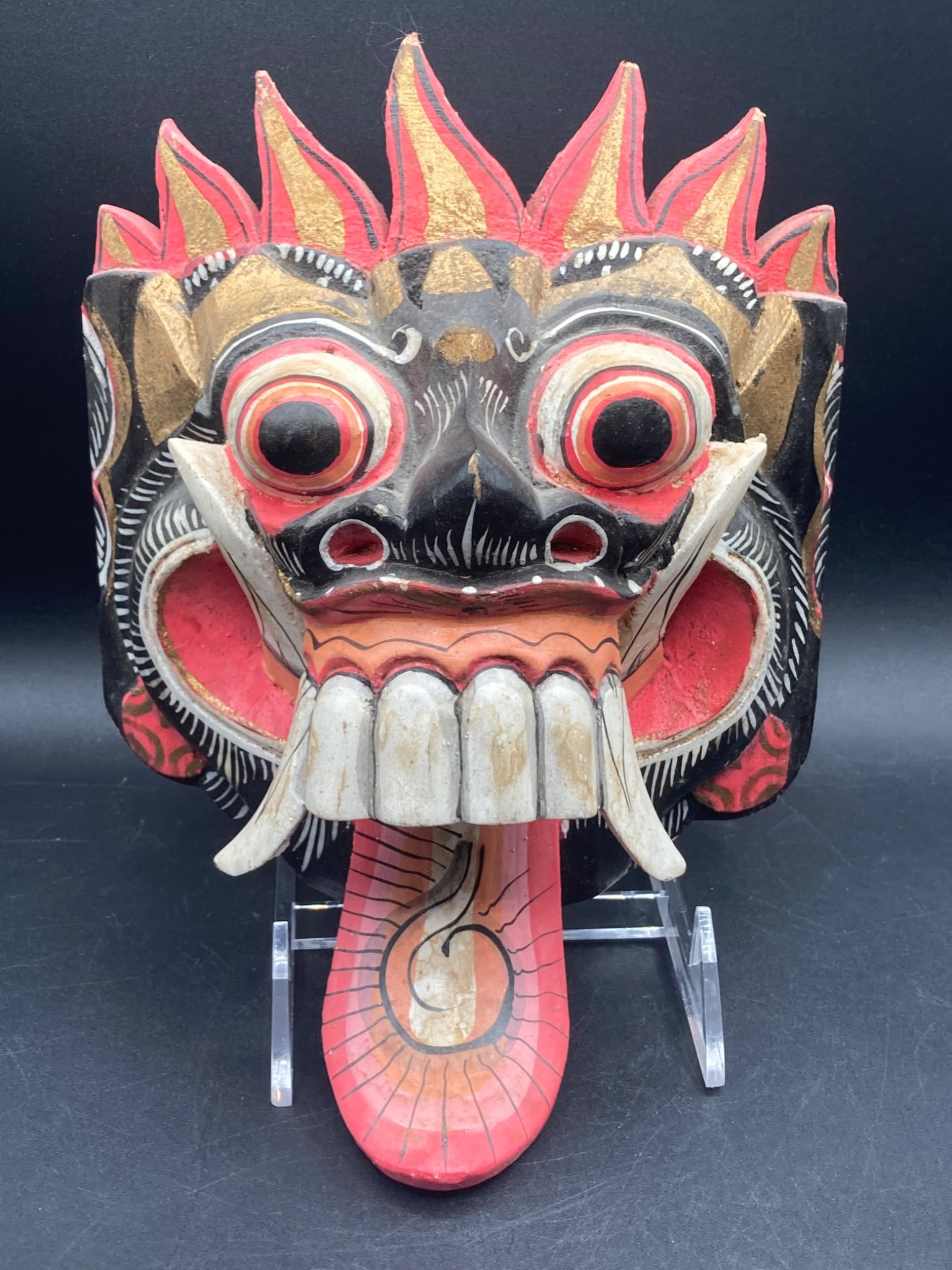 9" Indonesian Battle Demon Handcrafted Wood Mask: This is a 9-inch hand-carved and painted battle demon mask made of wood, originating from Indonesia. It features intricate craftsmanship with bold colors, including red, black, white, and gold. The ma