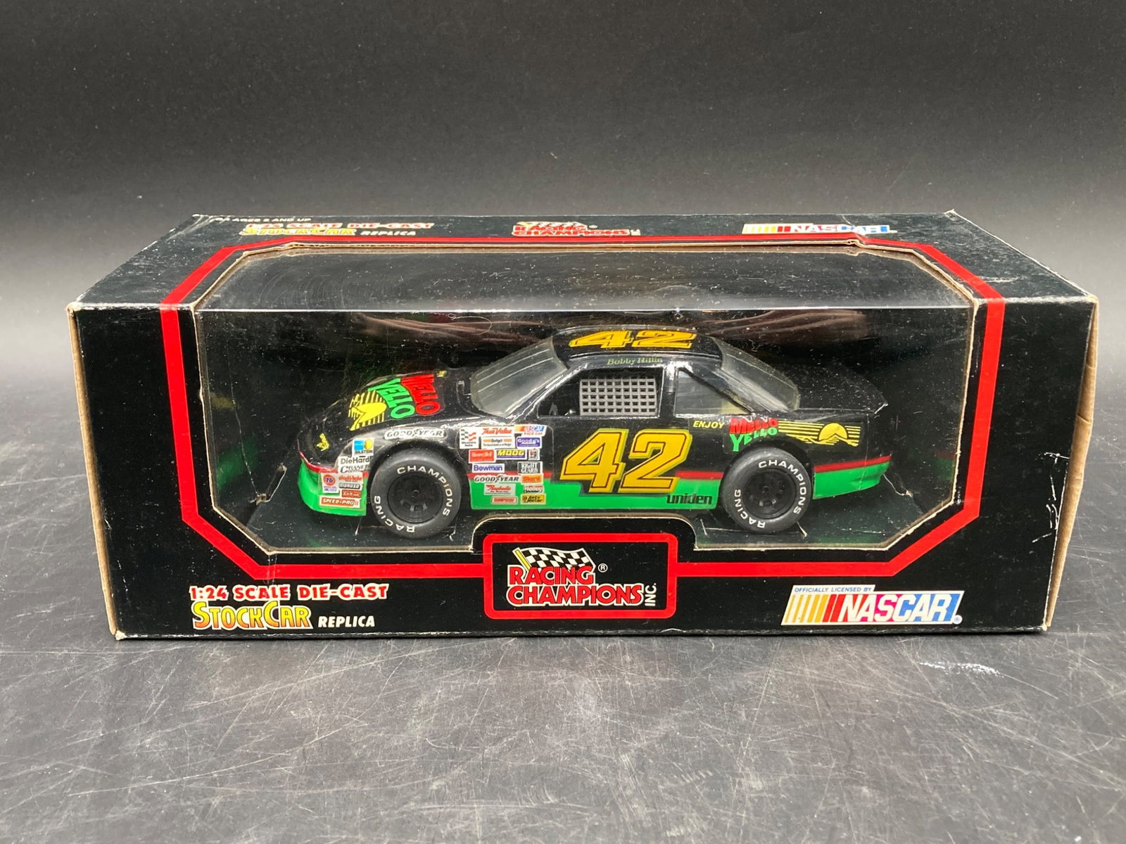 Racing Champions 1/24 Bobby Hillin Mello Yello Die Cast: This Racing Champions 1/24 scale die-cast model replicates the No. 42 NASCAR stock car driven by Bobby Hillin, featuring the iconic black, green, and yellow Mello Yello livery. The detailed car includ