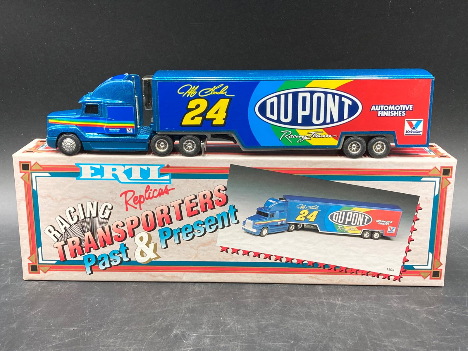 Ertl 1/64 1993 Jeff Gordon DuPont Semi Hauler Die-Cast: This Ertl 1/64 die-cast model from 1993 showcases Jeff Gordon™s DuPont Racing Team semi hauler. A collectible piece among NASCAR enthusiasts, it features vibrant graphics of the DuPont Automotiv